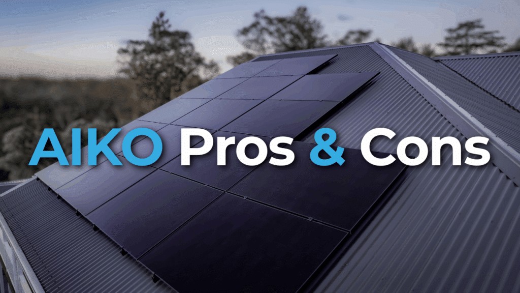 Close-up of dark solar panels installed on a sloped metal roof with trees in the background. Text overlay reads "AIKO Pros & Cons.