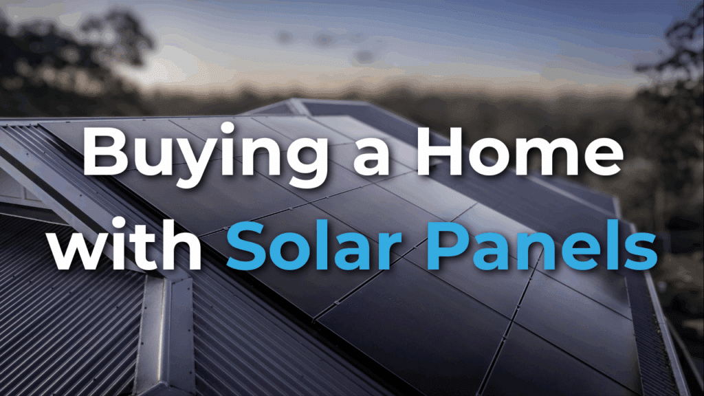 Close-up of rooftop solar panels at sunset with the text “Buying a Home with Solar Panels” overlaid on the image.