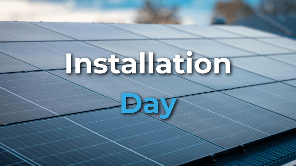 Rows of solar panels on a rooftop on a clear day, with the text "Installation Day" overlaid in large letters.