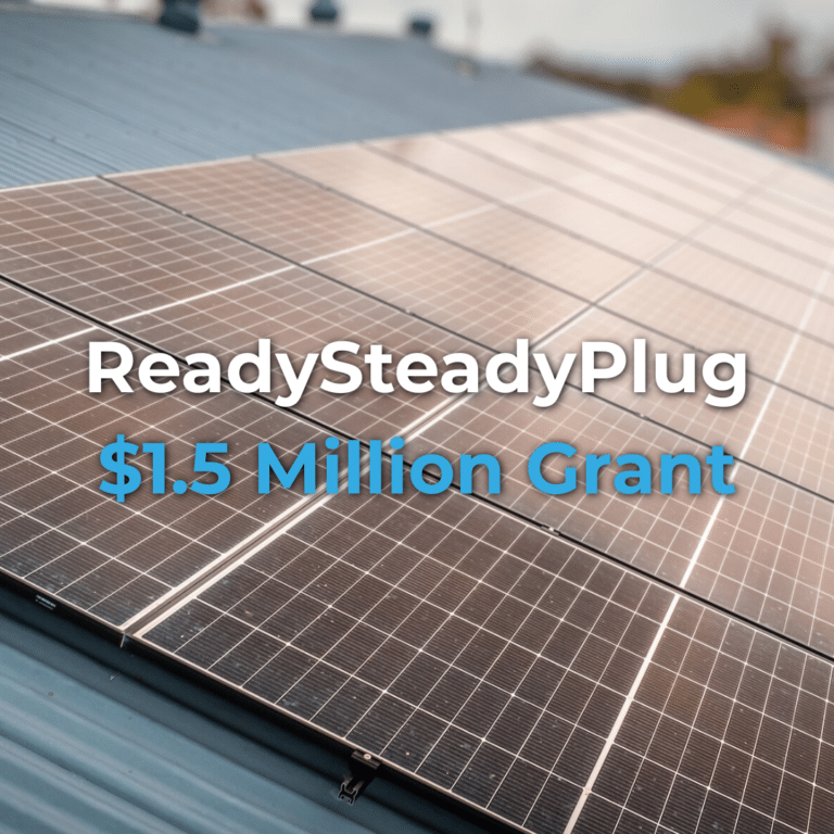 Close-up of solar panels on a rooftop with text overlay: “ReadySteadyPlug $1.5 Million Grant.”.