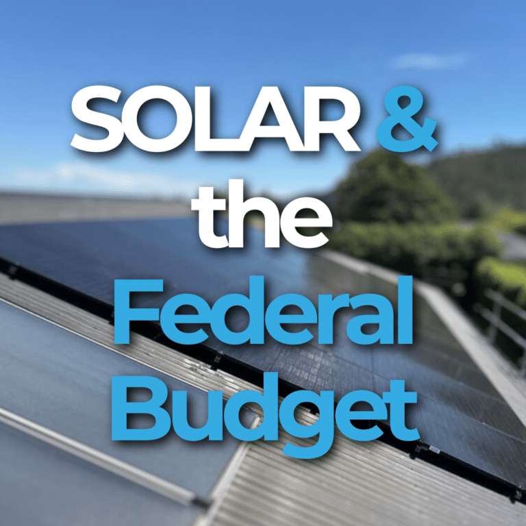 Close-up of solar panels on a roof with blue sky. Text overlay reads, "Solar & the Federal Budget.